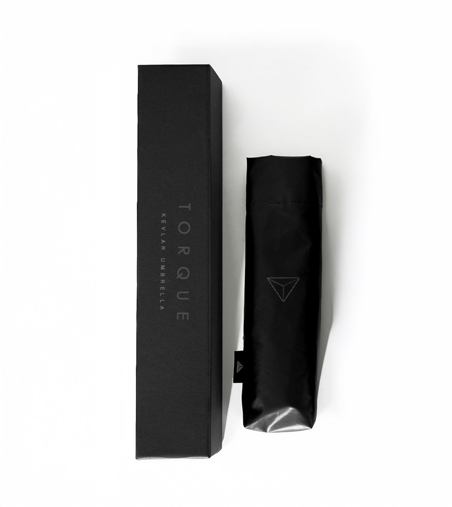 Black umbrella packaging with 'Torque' branding on a white background