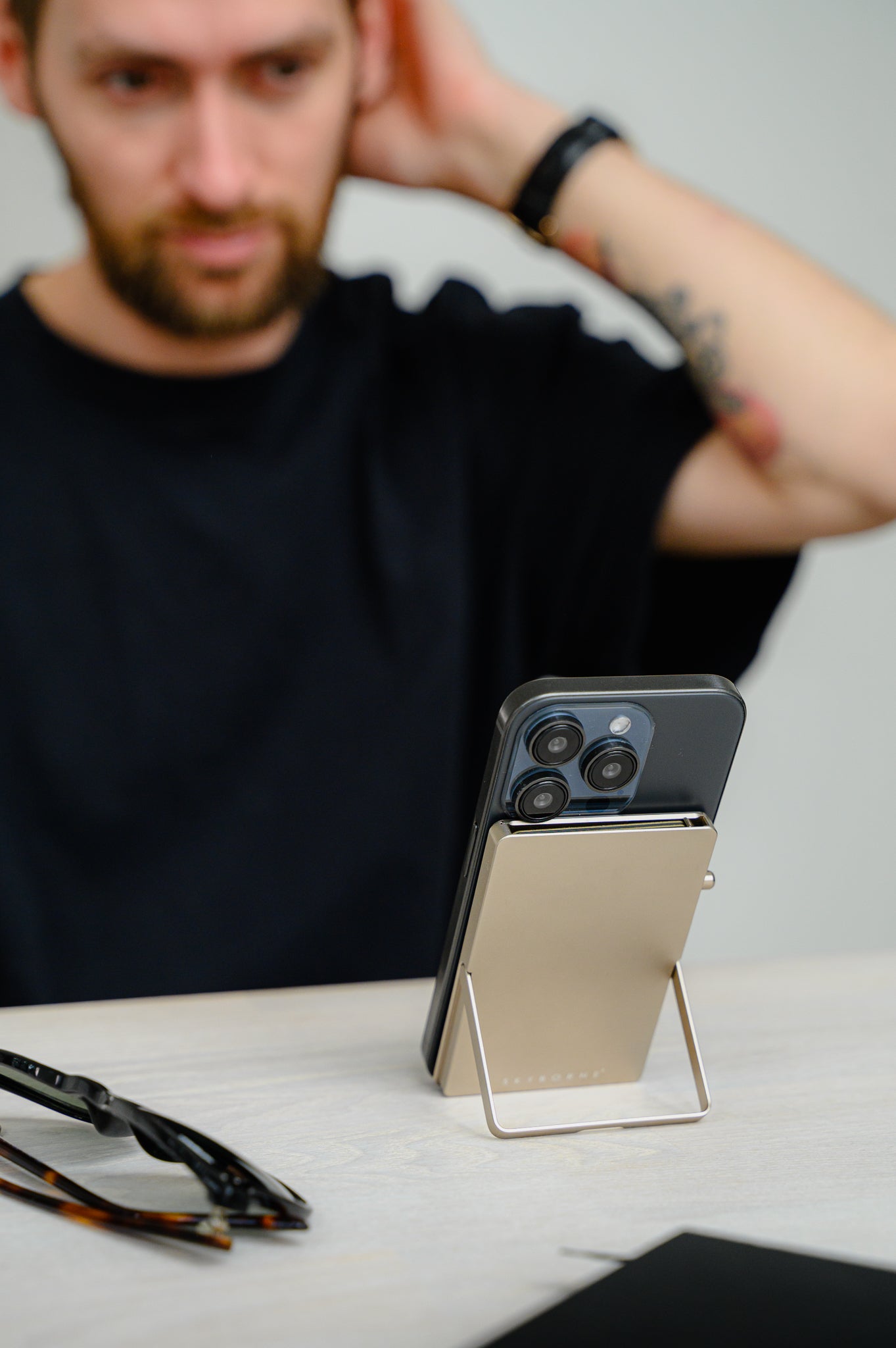 Person sitting at a table with a smartphone on a stand in front of them
